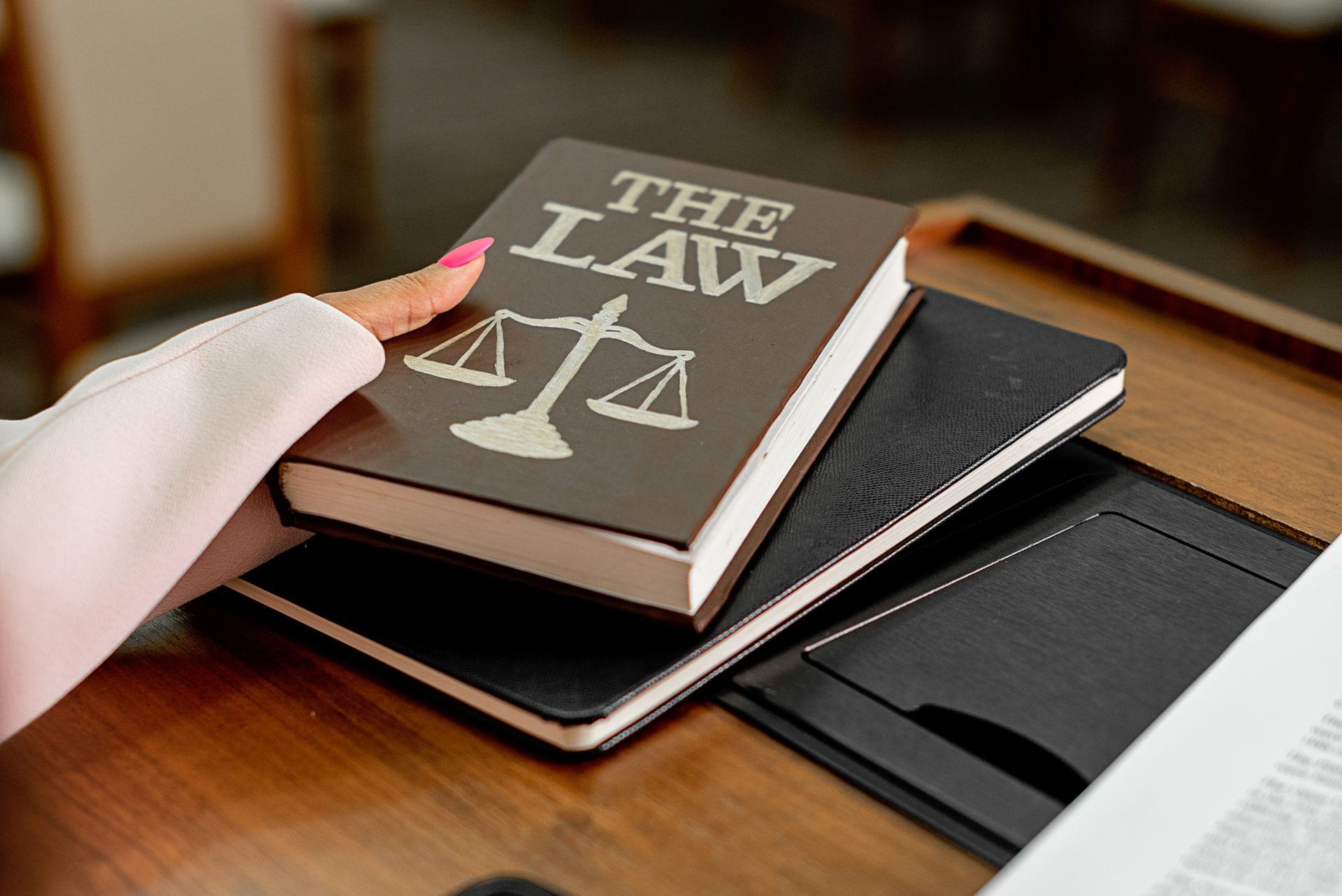 A hand resting on bound books of law